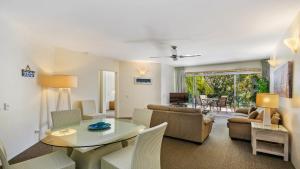 a living room with a table and a couch at Park Cove Apartments in Noosa Heads