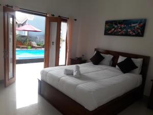 a bedroom with a bed and a swimming pool at Miko Bungalow Nusa Penida in Nusa Penida +32 photos