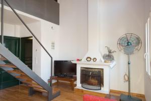 a living room with a fireplace and a tv at Casa di Campiello in Corfu