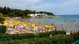 a crowded beach with a bunch of people in the water at Apartment Rosse in Split