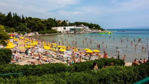 Ein überfüllter Strand mit einem Haufen Leute im Wasser in der Unterkunft Apartment Rosse in Split