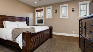 a bedroom with a large wooden bed and windows at Park'S Edge 844 Townhouse in Keetley Junction