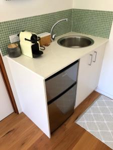 a small kitchen with a sink and a counter at Callemondah Studio with stunning views, in Bangalow and Byron Hinterland in Bangalow