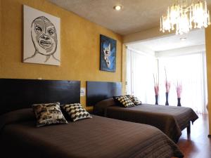 Un dormitorio con dos camas y un cuadro en la pared. en La Lotería Panoramic House & Rooftop by Lunian, en Guanajuato