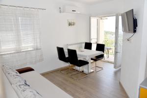 a living room with a dining room table and chairs at Apartments Antonio in Senj