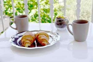 a plate of croissants on a table with two cups of coffee at Apartments Antonio in Senj