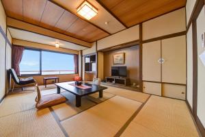 a living room with a table and a tv at Kokuya in Shibukawa