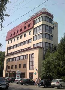 un gran edificio con coches estacionados frente a él en Hotel Ulitka, en Barnaul