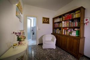 a room with a book shelf and a white chair at La Corte Apartment in Florence