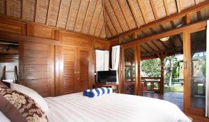 a bedroom with a bed with a television in it at Villa Sindu Ubud in Ubud
