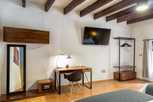 a bedroom with a desk and a tv on the wall at Morazul Hotel Boutique in Querétaro