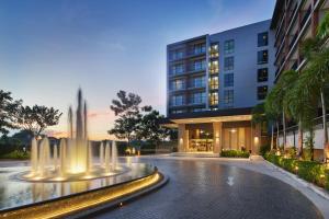 a building with a fountain in the middle of a street at The Park Nine Hotel Suvarnabhumi in Lat Krabang