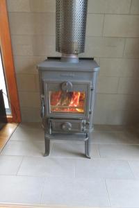 a stove with a fire in a room at Butterworth Cottage in Castlemaine