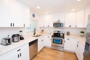 a kitchen with white cabinets and stainless steel appliances at Big Balcony - Parking Spot - King Bed - Fast WiFi in Long Beach