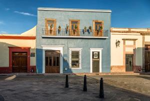 a blue building with flowers on a balcony at Morazul Hotel Boutique in Querétaro
