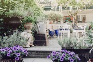 um jardim com uma fonte, cadeiras e flores em B&B Calidier em Cadier en Keer