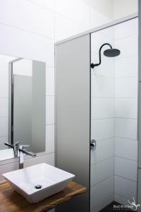 a white bathroom with a sink and a shower at Mad Monkey Kings Cross in Sydney