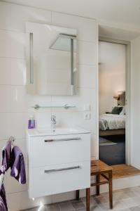 bagno bianco con lavandino e specchio di B&B Calidier a Cadier en Keer