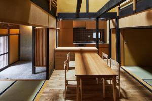 a dining room with a wooden table and chairs at Marukyo Gakurin-an in Kyoto