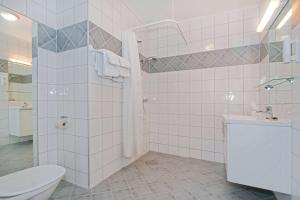 a bathroom with a toilet and a sink and a shower at Chesterfield Hotel in Trondheim +58 photos