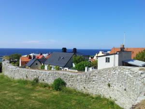 una pared de piedra con casas y el océano en el fondo en Best Western Solhem Hotel, en Visby