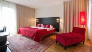 a bedroom with a red bed and a red chair at Best Western Plus Time Hotel in Stockholm