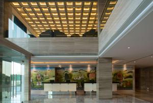 a lobby of a building with a painting on the wall at Hyatt Regency Ludhiana in Ludhiana
