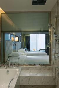 a large bathroom with two beds and a bath tub at Hyatt Regency Ludhiana in Ludhiana