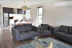 a living room filled with furniture and a kitchen at cluBarham Golf Resort in Barham