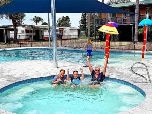 un grupo de personas en una piscina en Ingenia Holidays Moruya, en Moruya