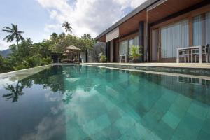 a swimming pool in front of a house at The Puncak Lombok in Senggigi