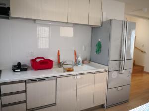 a kitchen with white cabinets and a refrigerator at Katsuragawa House in Kami-tobachō