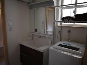 a small bathroom with a sink and a mirror at Katsuragawa House in Kami-tobachō +22 photos