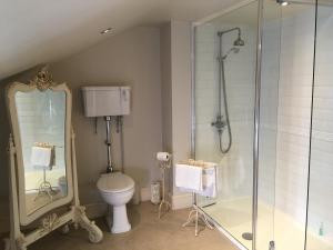 a bathroom with a toilet and a glass shower at Lilly's Pad in Keelby