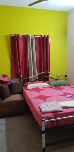 a bedroom with a bed with a red curtain at Avvairam Service Apartment - C9 in Chennai