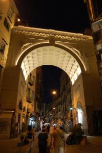 Un groupe de personnes marchant sous une arche au-dessus d'une rue dans l'établissement Cico B&B, à Naples