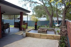a patio with a bench and a hammock at Abbey Beach Cottage in Busselton