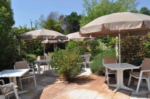 a group of tables and chairs with umbrellas at Atlantis Hôtel in Mimizan