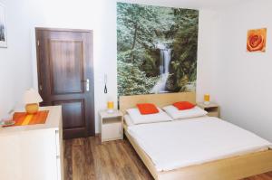 a bedroom with two beds and a waterfall painting on the wall at Vila Renáta - Apartmán Renáta 12 in Ružomberok