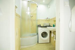 a bathroom with a shower and a washing machine at Waksa in Gdynia