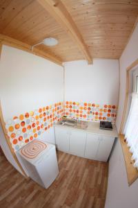 a small kitchen in a small house with a wooden ceiling at Rodzinna Kraina in Ustka