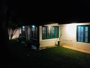 a house with green windows at night at Ella Escapade Hostel by Nomadic in Ella