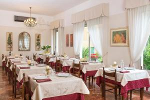 un comedor con mesas con manteles blancos en Hotel Olimpia, en Bellaria-Igea Marina