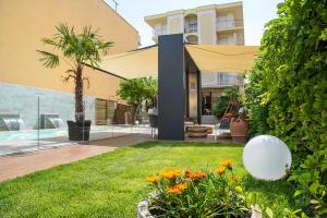 un patio trasero con piscina y una casa en Hotel Olimpia, en Bellaria-Igea Marina