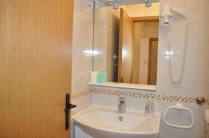 uma casa de banho com um lavatório e um espelho em Apartments Ljubica em Makarska