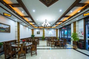 a restaurant with tables and chairs and a chandelier at W_Smart Motel Superior Hongcun in Yi