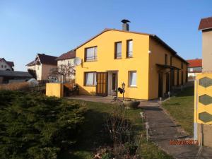 una casa amarilla al lado de un patio en Ferienhaus Hering, en Neu Porschdorf
