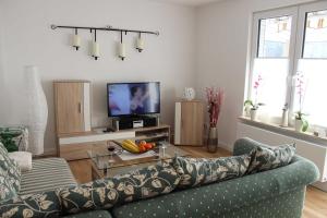 a living room with a couch and a tv at Befeld Susanne in Neustadt in Holstein