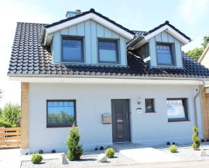 a blue and white house with a black door at Befeld Susanne in Neustadt in Holstein