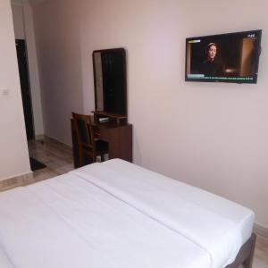 a hotel room with a bed and a television at Safyad Hotel in Yaoundé